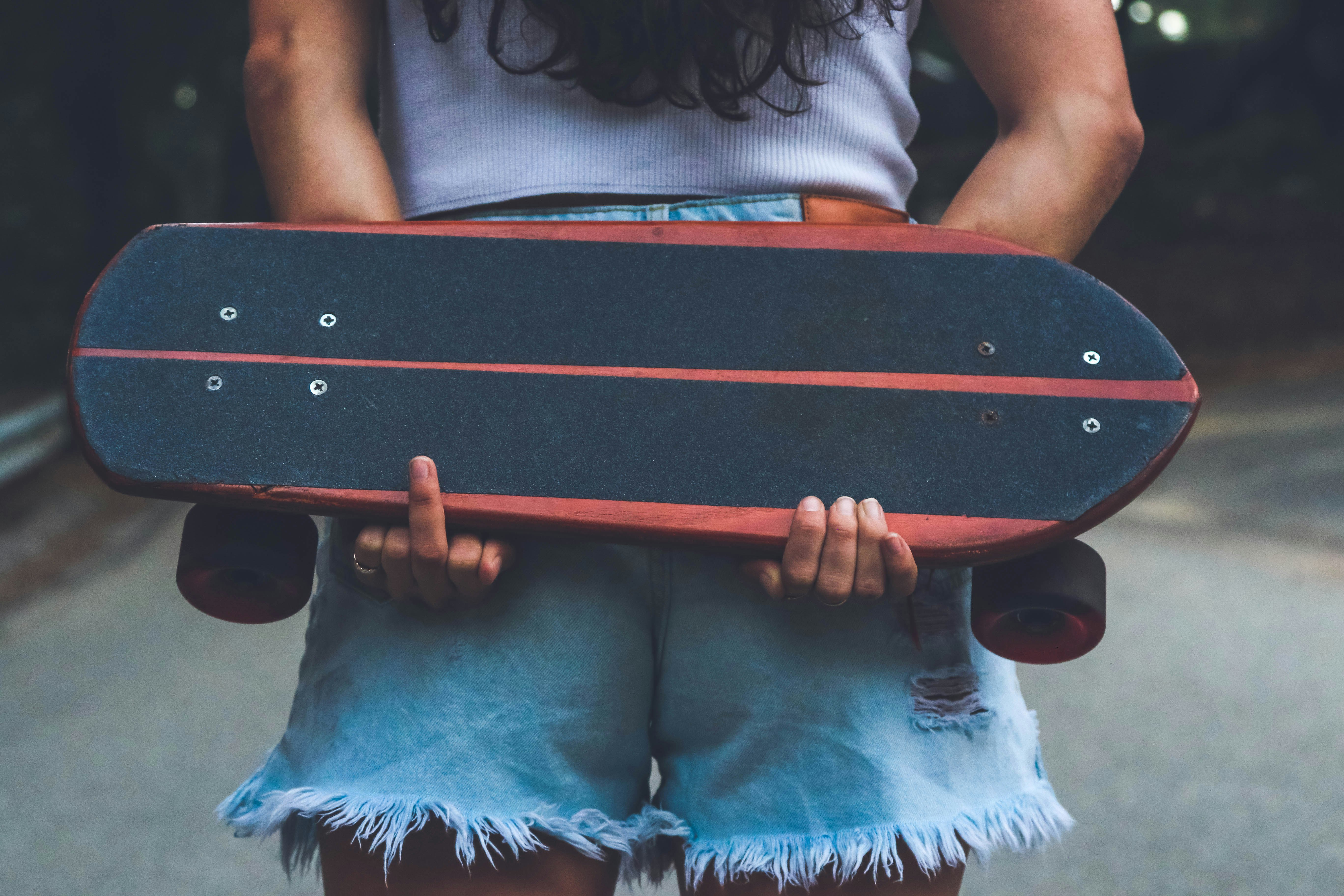 woman holding brown and black skateboard